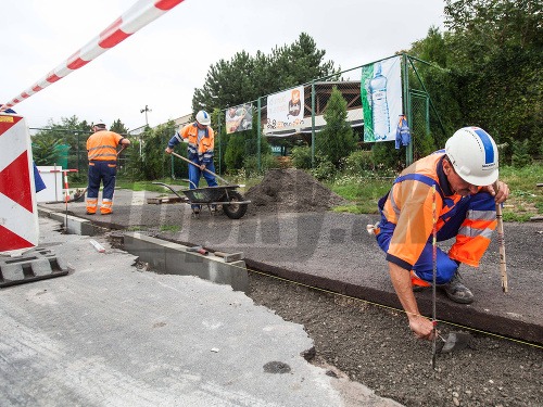 Robotníci pracujú na výstavbe úseku cyklotrasy v Bratislave.
