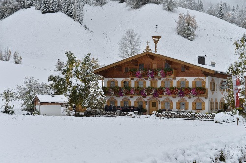 Hochfilzen v rakúskom Tirolsku. Na balkónoch sú stále muškáty, ale krajina je pod snehom.
