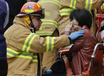 Hasič pomáha cestujúcej, ktorú evakuovali z vykoľajenej súpravy metra v newyorskej štvrti Queens