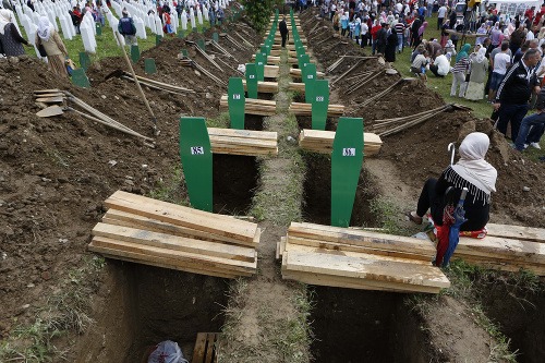 Žena sa prechádza popri hroboch obetí srebrenického masakru