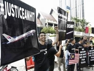 Demonštranti držia transparenty počas protestu pred ukrajinským veľvyslanectvom v malajzijskej metropole Kuala Lumpur.