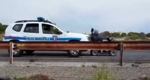 Policajti pred sebou tlačia vozíčkara, aby sa v bezpečí mohol dostať domov