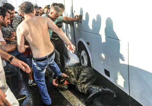 Ľudia bijú a kopú tureckého vojaka, ktorý bol zapojený do pokusu o prevrat.