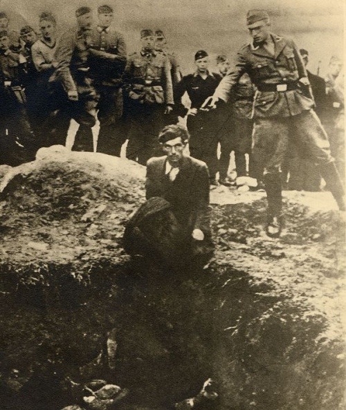 Zabijak z Einsatzgruppen sa chystá zastreliť Žida kľačiaceho nad masovým hrobom