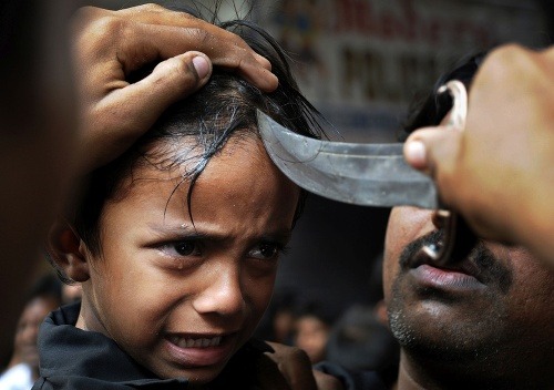 Malý indický šíit plače, keď mu otec reže čelo nožom na pochode pri príležitosti sviatku ašúra v Hajdarábáde. (6. decembra 2011)