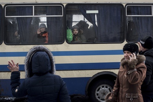 Deti mávajú z okna autobusu svojim príbuzným počas evakuácie z mesta Avdijivka, ktoré sa stalo v posledných dňoch epicentrom bojov do Sviatohirska, ďaleko od frontovej línie na východe Ukrajiny