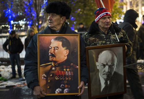 Oslavy výročia boľševickej revolúcie. Ľudia držia portréty Josifa Stalina (vľavo) a Vladimíra Lenina.