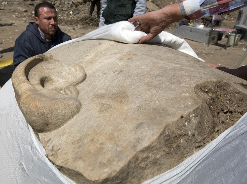 Na snímke archeológovia zakrývajú hlavu obrovskej sochy, ktorá zrejme zobrazuje Psammetika I.