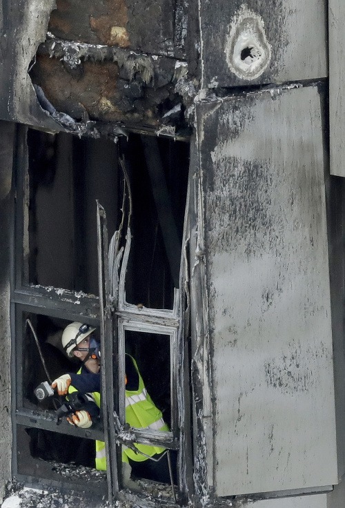 Hasiči prehľadávajú zhoretý interiér Grenfelskej veže v Londýne po požiari, ktorý usmrtil najmenej 30 ľudí.