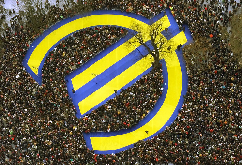 Dobová fotografia z 1. januára 1999 zachytáva tisíce ľudí stojaci okolo symbolu eura. 