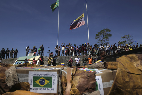Ľudia zoskupení okolo dodávky s prvou humanitárnou pomocou