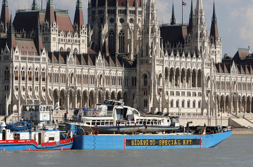 Na snímke bager na pontóne nesie vyhliadkovú loď po jej vytiahnutí z dna na mieste potopenia pri Margitinom moste počas plavby na Dunaji okolo budovy parlamentu 11. júna 2019 v Budapešti. 