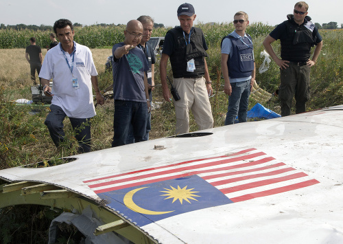 Fotografia zhotovená 23. júla 2014. Malajzijskí vyšetrovatelia spolu s členmi misie OBSE na Ukrajine preskúmali kus havarovaného letu leteckých spoločností Malaysia Airlines