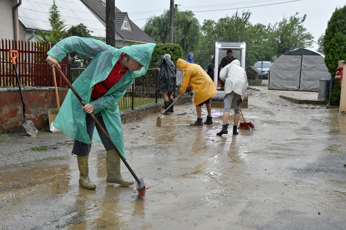 Na snímke odpratávanie vody a bahna zo zaplavenej ulice v obci Ratnovce.