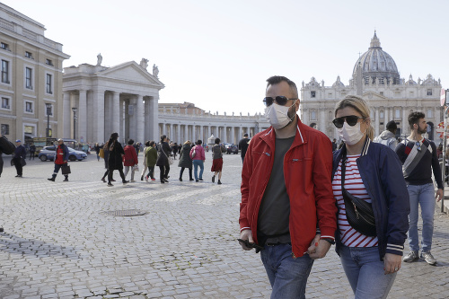Dvojica nosí rúška počas prechádzky na námestí Sv. Petra vo Vatikáne.
