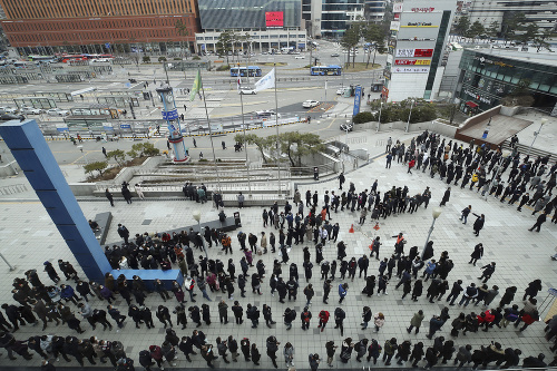 Ľudia čakajú v rade na nákup ochranných rúšok pred železničnou stanicou v Soule