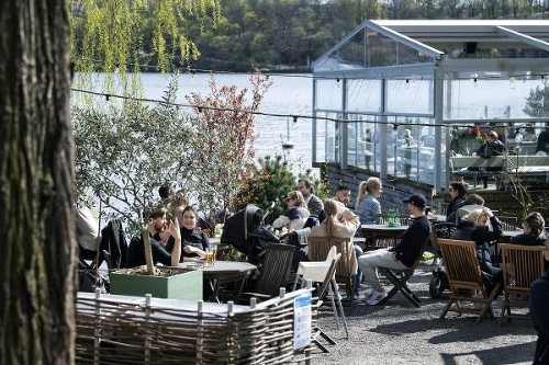 Ľudia sedia v reštaurácii v Štokholme počas pandémie 