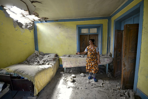 Miestna žena ukazuje svoj zničený dom po náletoch arménskej armády počas bojov v regióne Tovuz ležiacom na severozápade Azerbajdžanu v utorok 14. júla 2020. 