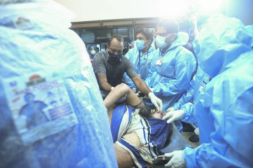 Zraneného cestujúceho z havarovaného lietadla privážajú na nosidlách do nemocnice v meste Kalikat