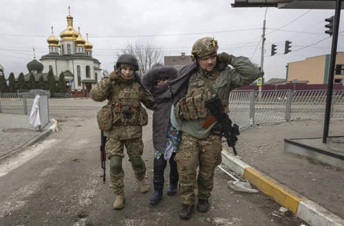 Ukrajinskí vojaci pomáhajú zranenej žene.