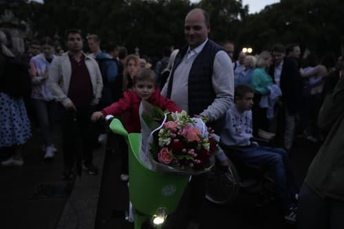 Rodiny prichádzajú na námestie pred Buckinghamským palácom s kyticami kvetov, aby sa rozlúčili so svojou kráľovnou.