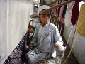 Pakistanské dieťa tká koberec