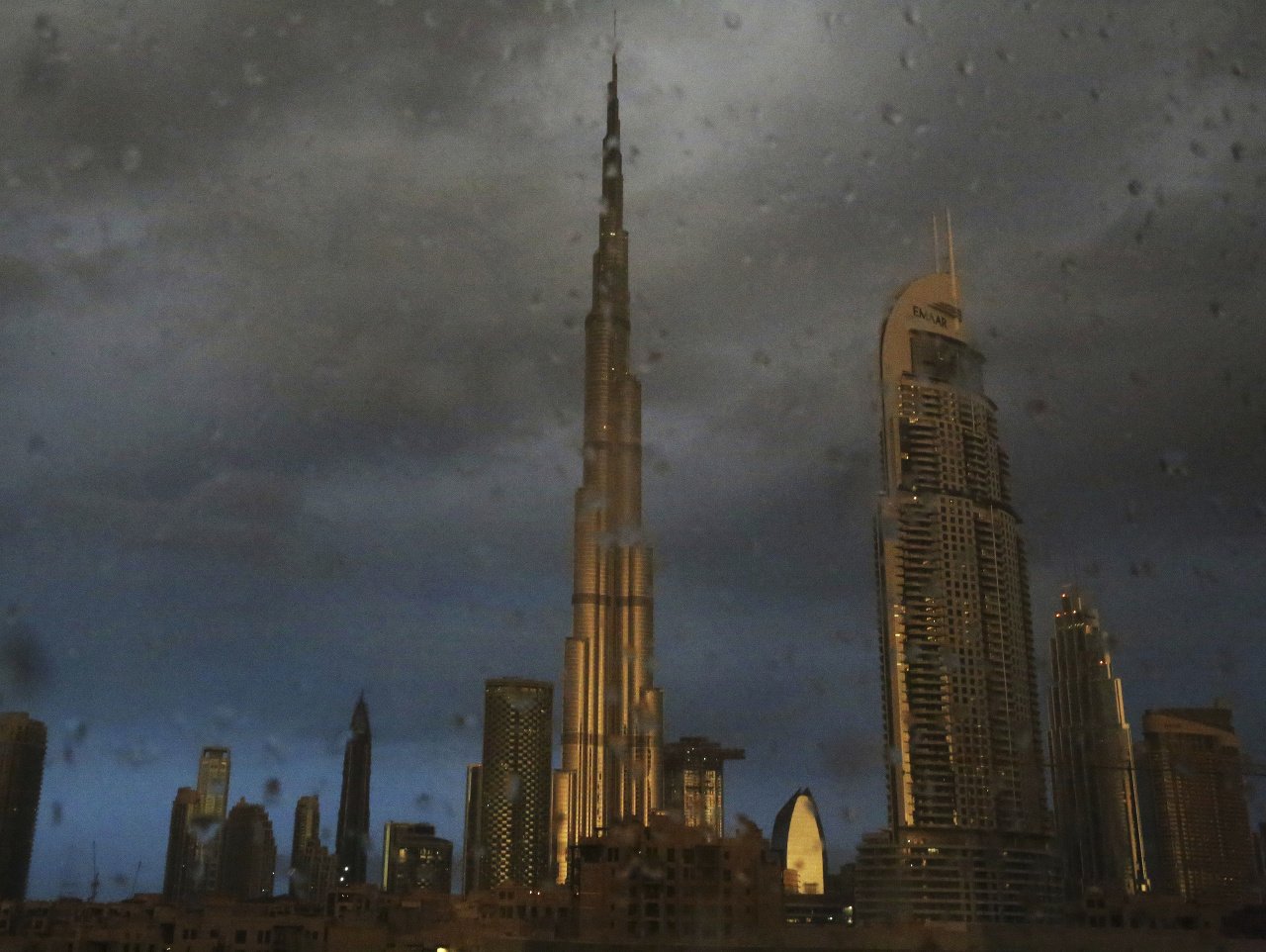 Slnečné svetlo sa odráža na najvyššej budove sveta, 828 metrov vysokom mrakodrape Burdž chalífa (v strede) počas dažďovej prehánky v Dubaji v Spojených arabských emirátoch.