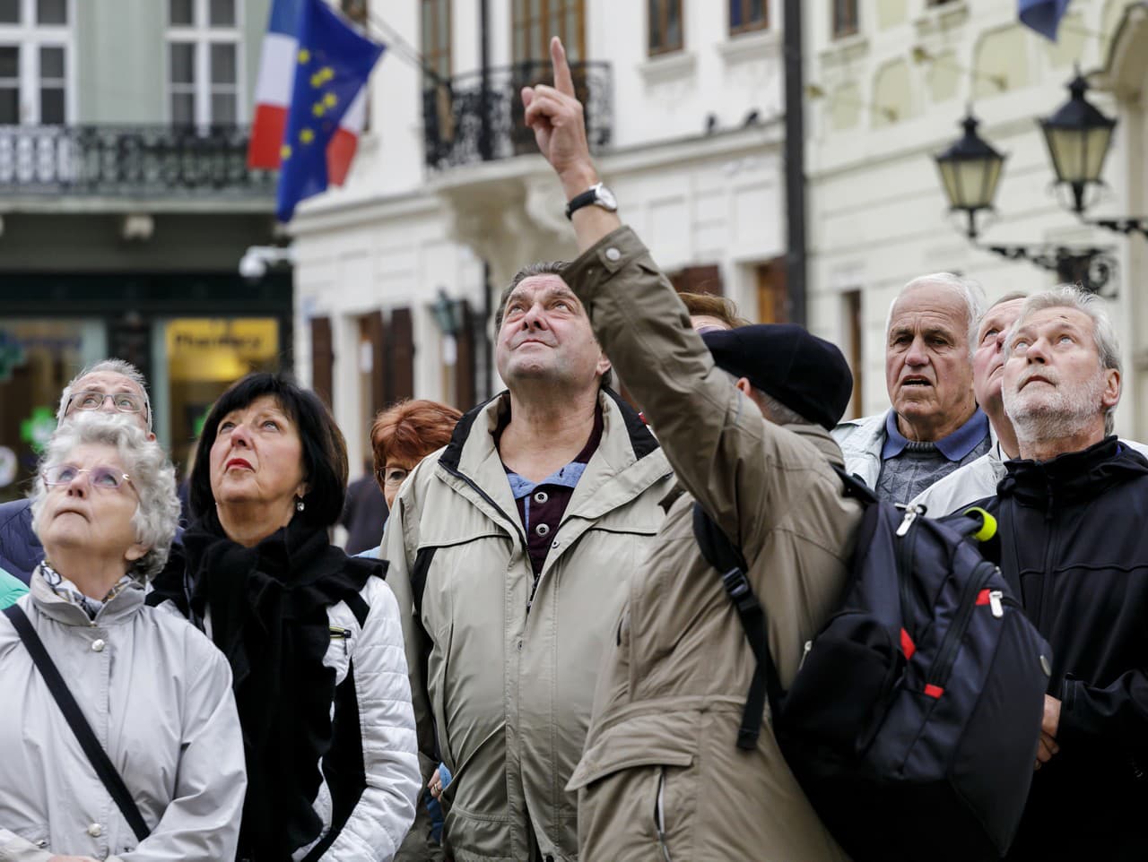 Na snímke sprievodca ukazuje zahraničným turistom na vežu Starej radnice v Bratislave.