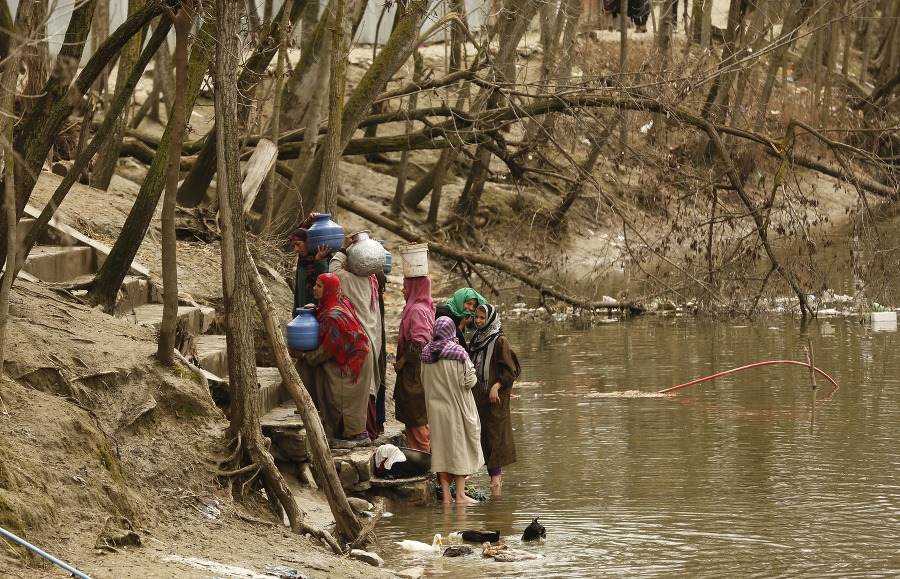 Ženy sa chystajú na cestu domov s vodou z rieky v džbánoch.