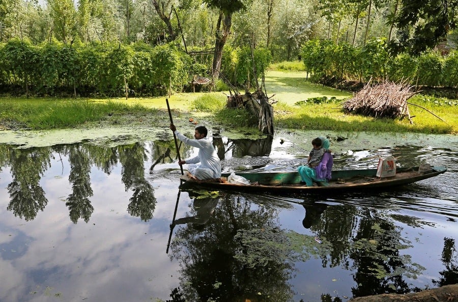Kašmírčania sa vezú v člne na jazere Dal.