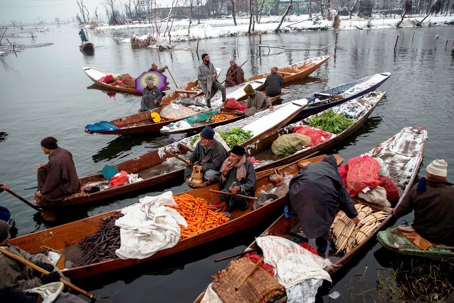 Na snímke Kašmírčania predávajú tovar na improvizovanom trhu z člnov na jazere Dal v chladnom ráne.