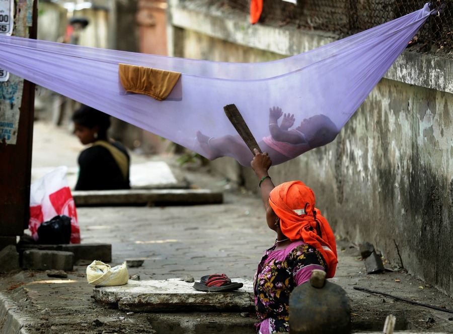 Na snímke indická žena kolíče svoje dieťa pri práci na ulici v Bombaji.