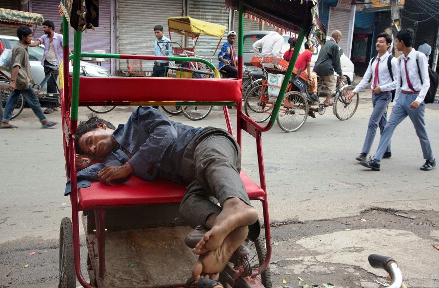 Rikšiar spí v skorých ranných hodinách v starej štvrti metropoly Naí Dillí.
