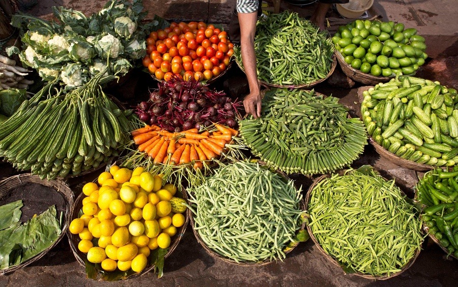redavač aranžuje zeleninu na trhu v indickom Gauhátí.