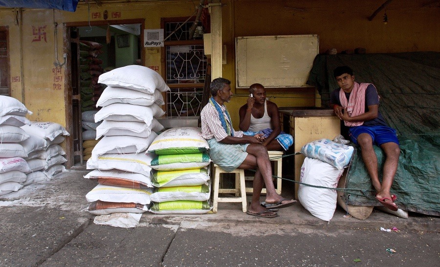 Indickí robotníci čakajú na začiatok pracovného dňa  na trhu.