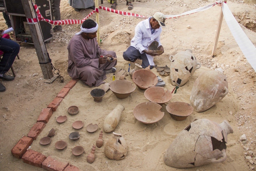 Egyptskí robotníci reštaurujú keramické nádoby neďaleko znovuobjavenej hrobky.