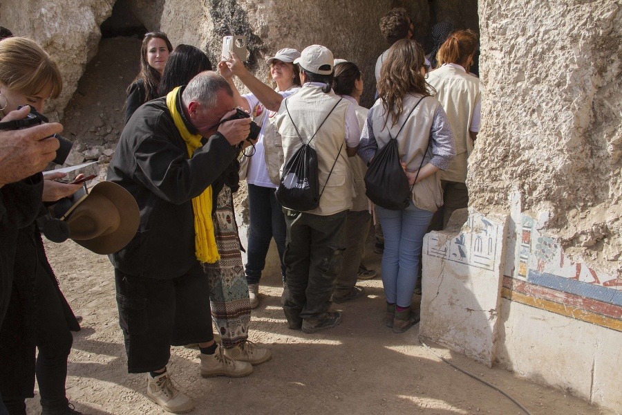 Turisti si fotografujú vstup do znovuobjavenej hrobky v Luxore.