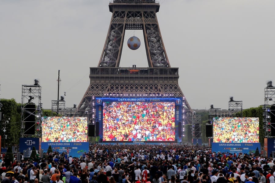 Ľudia sledujú na veľkoplošných obrazovkách úvodný zápas majstrovstiev Európy vo futbale medzi Francúzskom a Rumunskom 10. júna 2016.
