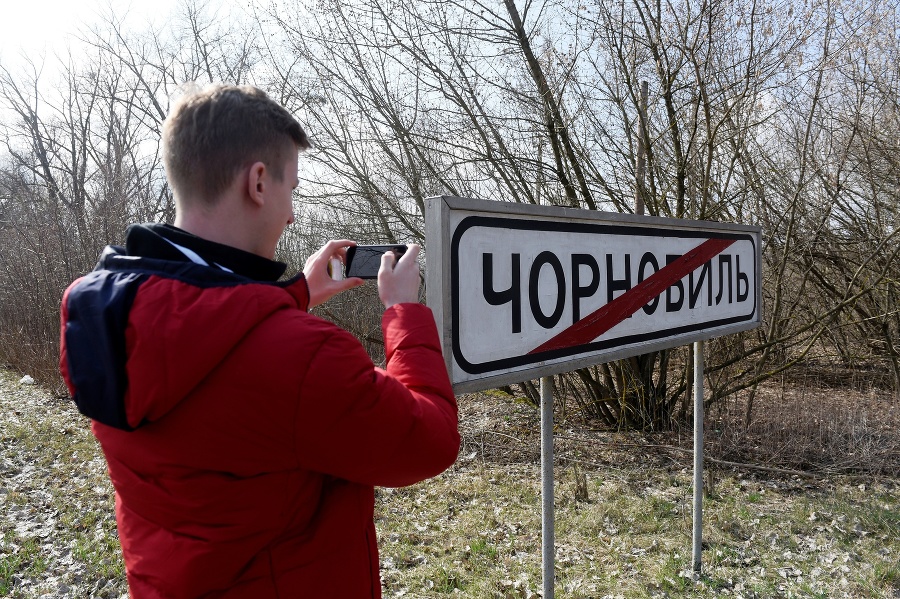 Turista si fotografuje tabuľu s nápisom Černobyľ.