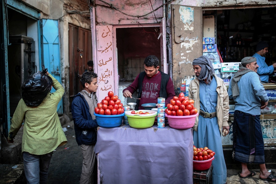 Predavač ponúka paradajkové čatní na trhu v Saná.