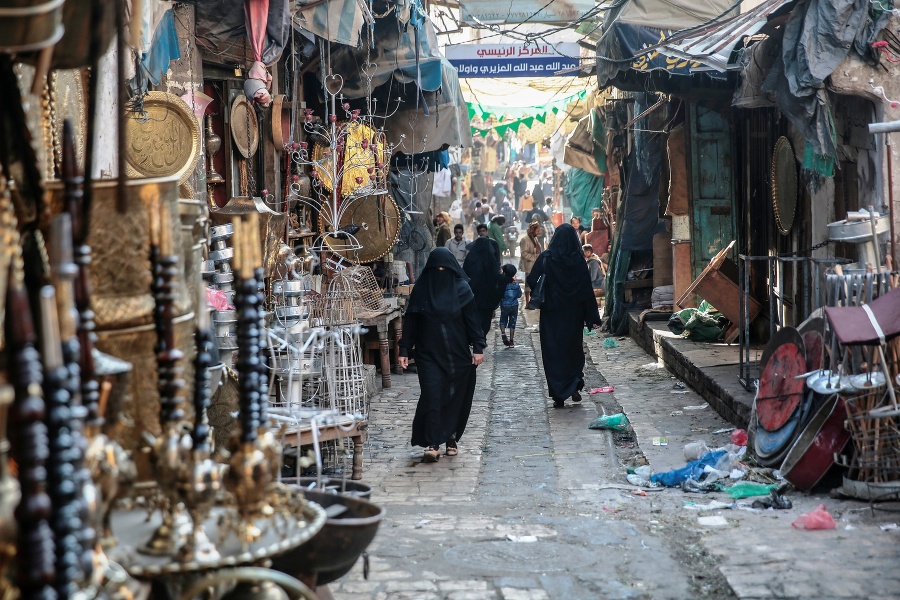 Jemenské ženy prechádzajú medzi stánkami na trhovisku.