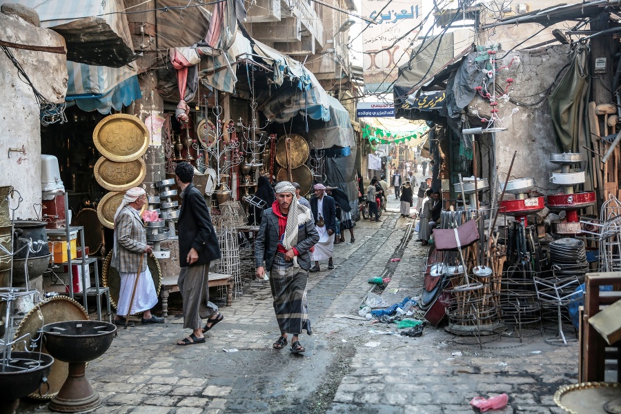 Ľudia prechádzajú medzi stánkami s kovovým tovarom na tradičnom trhovisku Souk almelh v hlavnom meste Saná.