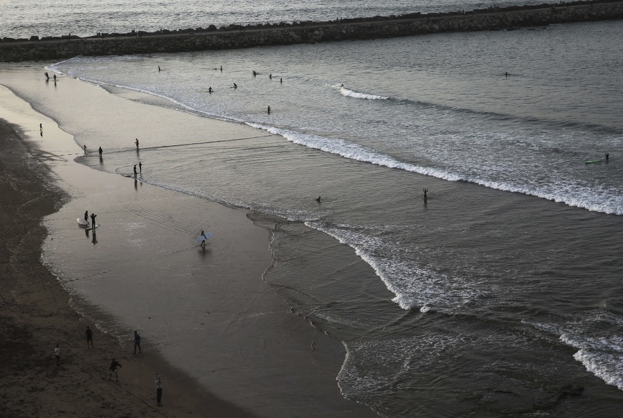 Ľudia si užívajú podvečerné slnko pri Atlantickom oceáne na pláži v marockom Rabate. Pláž je vyhľadávaný miestom pre pasívny aj aktívny oddych najmä v teplom počasí.