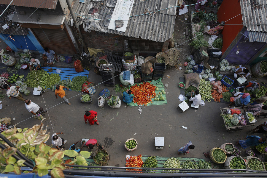 Ľudia nakupujú u pouličných predavačov zeleninu v Kalkate.