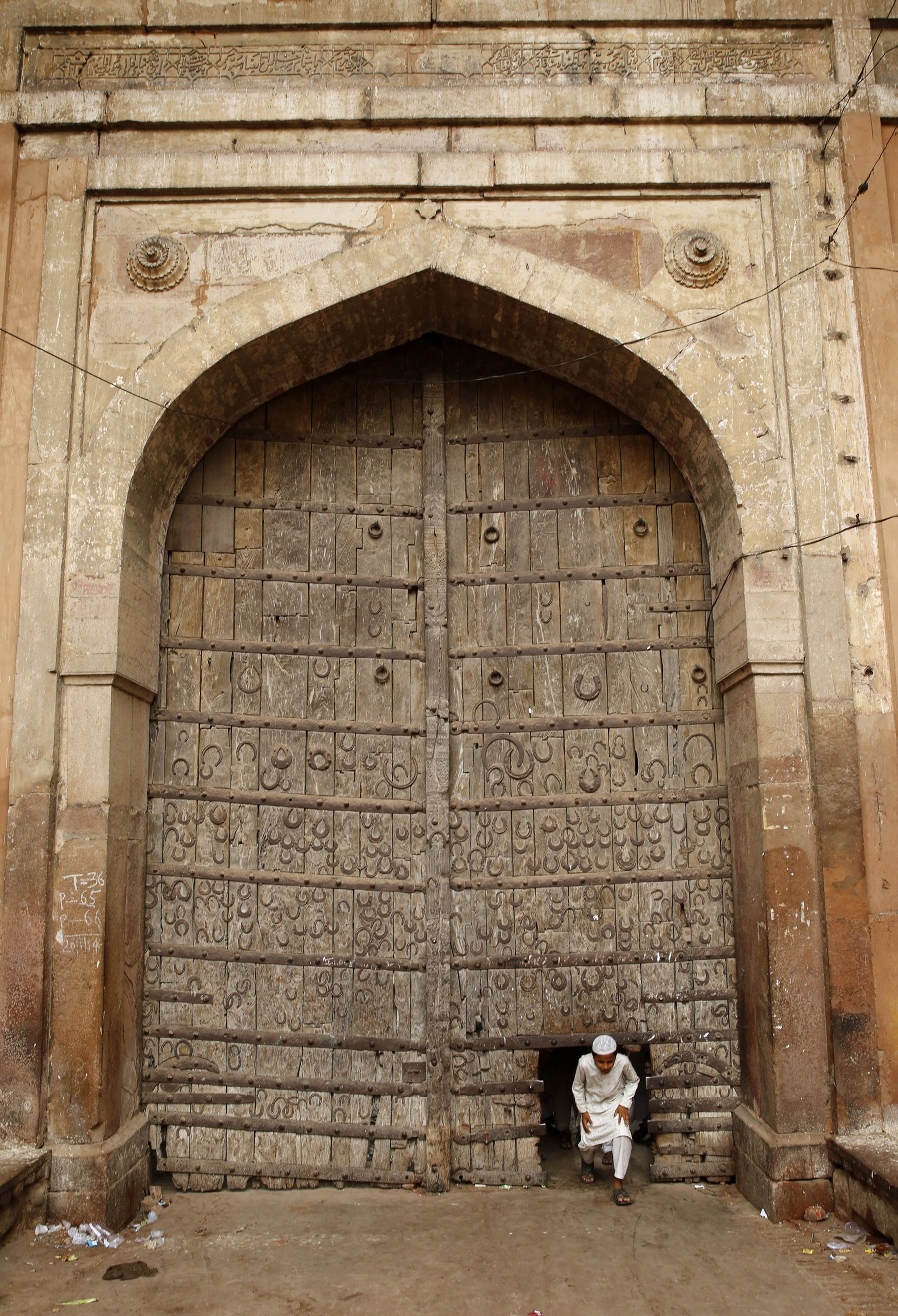 Chlapec prechádza cez starú bránu, ktorá je zdobená podkovami, v Allahabáde.