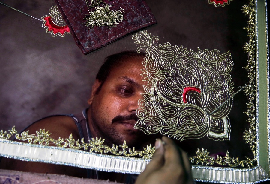 Indický zamestnanec vyrába sárí, tradičný ženský indický odev, v meste Lucknow.