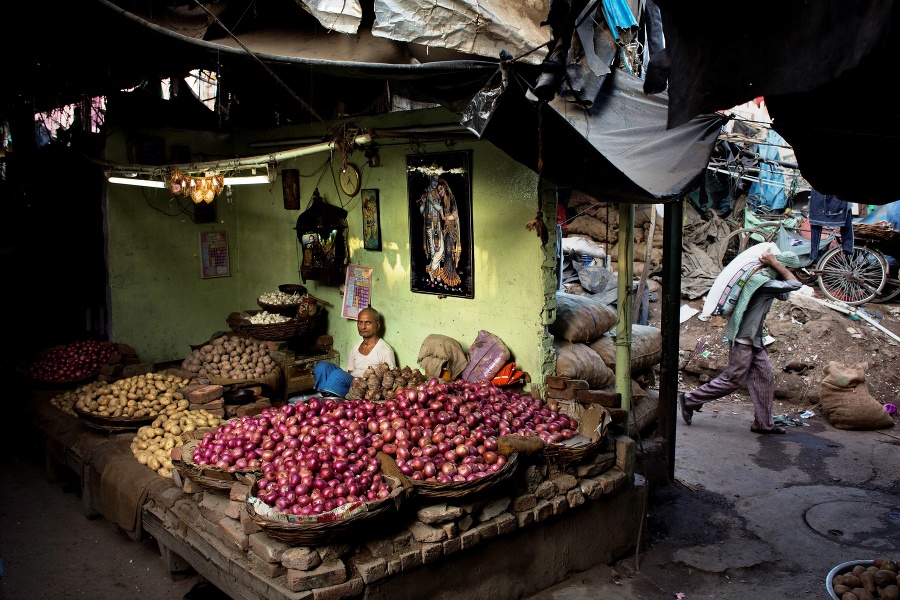 Pouličný predavač predáva cibuľu a zemiaky  v starej časti metropoly Naí Dillí.