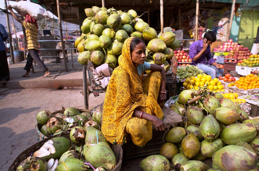 Indka s kokosmi čaká na zákazníkov na trhu v indickom Gauhátí.