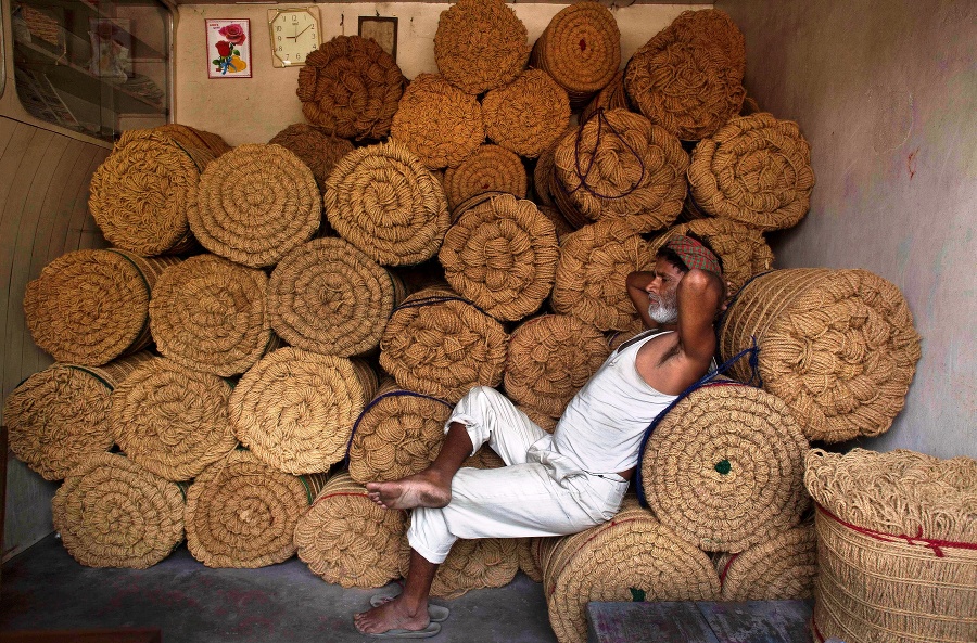 Ind oddychuje na zväzkoch kokosového vlákna vo svojom obchode v Gauhátí.