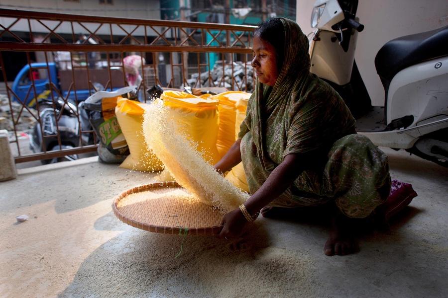 Na snímke žena čistí ryžu na trhovisku v indickom meste Gauhátí.